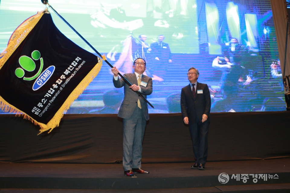 중소기업융합충북연합회 기를 이양받아 흔들고 있는 박광석 회장의 모습